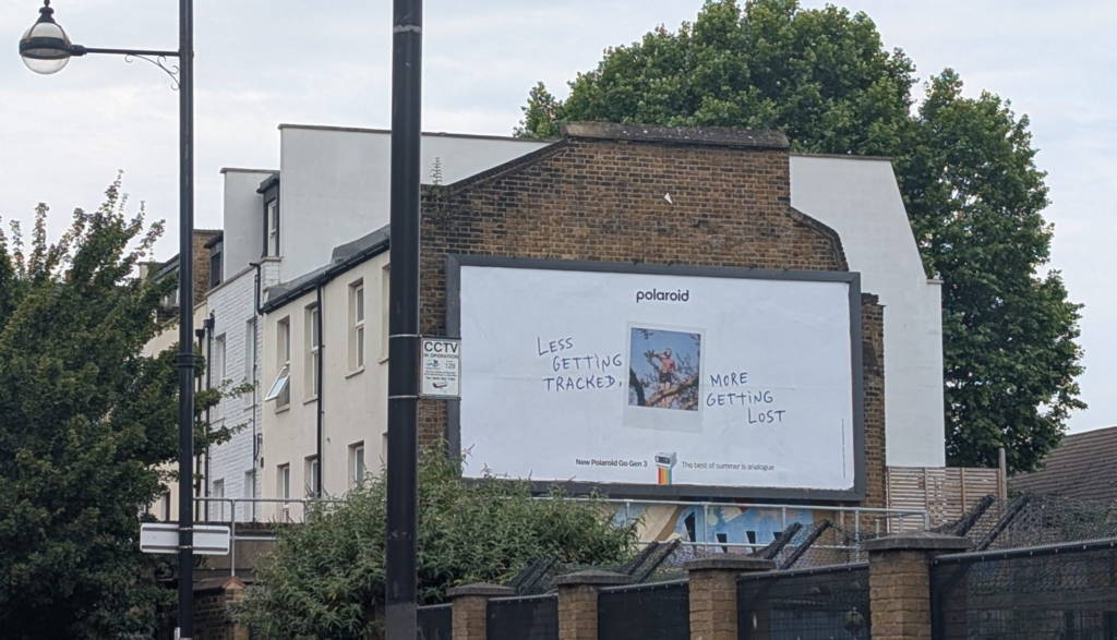 Polaroid created billboard that asks you to step from your and enjoy the nature